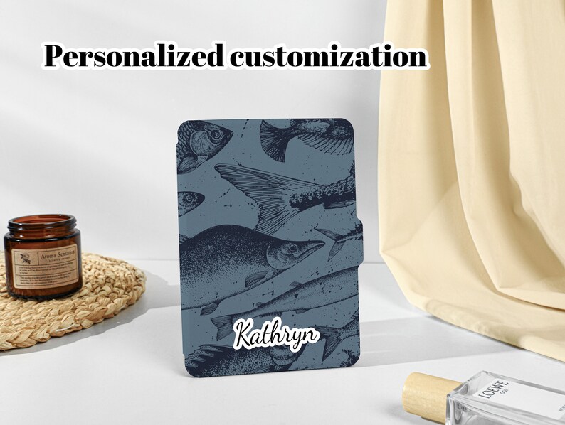 May include: A blue phone case with a personalized name, "Kathryn", and a vintage illustration of fish.