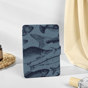 May include: A blue and white patterned e-reader cover with a design of various fish.