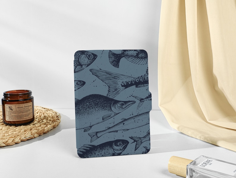 May include: A blue and white patterned e-reader cover with a design of various fish.