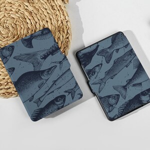 May include: Two blue e-reader covers with a pattern of black fish silhouettes.