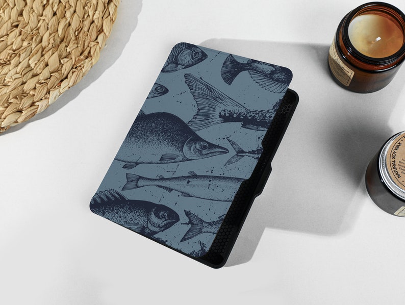 May include: A blue and black e-reader cover with a pattern of fish illustrations.