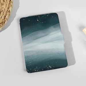 以下が含まれることがあります： ゴールドのグリッターのアクセントが付いた、ティールブルーとホワイトの抽象的なデザインのブックカバーです。