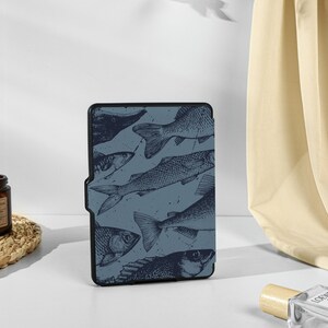 May include: A blue and black e-reader cover with a pattern of fish. The cover has a textured surface and a subtle sheen.