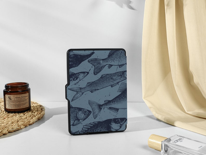 May include: A blue and black e-reader cover with a pattern of fish. The cover has a textured surface and a subtle sheen.