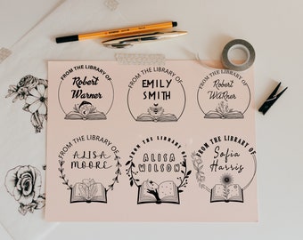 May include: Six black and white printable bookplate designs with floral accents and the text "From the Library of" followed by a name. The designs feature a book with a floral design, a bee, a moon, and stars.