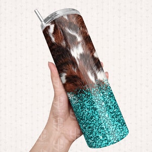 May include: A stainless steel tumbler with a cowhide pattern and a turquoise glitter bottom. The tumbler has a silver straw and a silver lid. The design is a mix of rustic and glam.