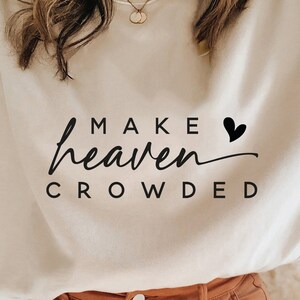 May include: A beige sweatshirt with the text "MAKE heaven CROWDED" and a small black heart.