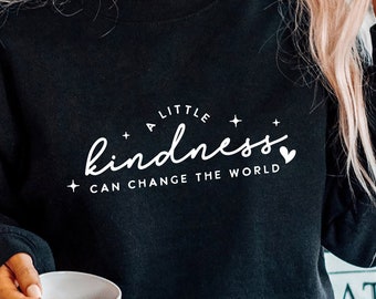 May include: A black sweatshirt with a white graphic that says "A little kindness can change the world" with a small heart icon.