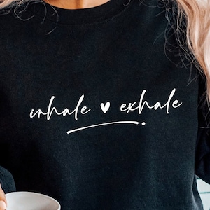 May include: Black sweatshirt with the text "inhale ♥ exhale" in white lettering.