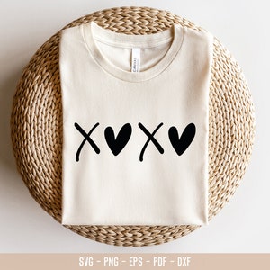 May include: A white t-shirt with a black graphic of the letters "XO" with a heart between each letter.
