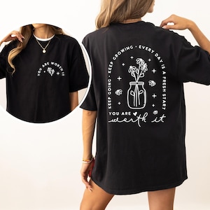 May include: Black oversized t-shirt with a white graphic print of a mason jar with flowers and the text "Keep going. Keep growing. Every day is a fresh start. You are worth it."