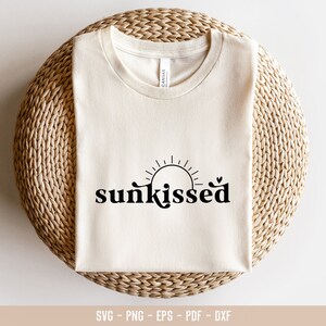 May include: A white t-shirt with the text "sunkissed" in black lettering. The text is stylized with a sun graphic above it.