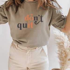 May include: A grey t-shirt with the text "don't quit" in orange and black lettering.