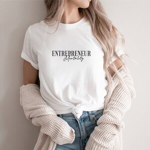 May include: White t-shirt with the text "ENTREPRENEUR Mentality" in black lettering.