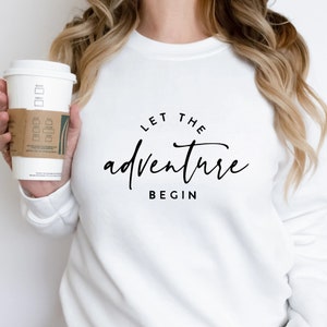 May include: White sweatshirt with black text that reads "Let the adventure begin".