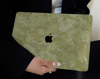 Puede incluir: Una piel de portátil de mármol verde con un logotipo de Apple plateado. La piel tiene un color verde claro con vetas verdes más oscuras.
