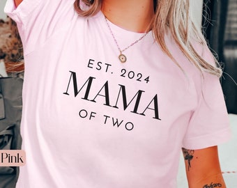 May include: A soft pink t-shirt with the text "EST. 2024 MAMA OF TWO" printed in black.