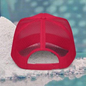 May include: A red mesh trucker hat with a black brim and a snap closure. The hat is made of a breathable material and is perfect for casual wear.