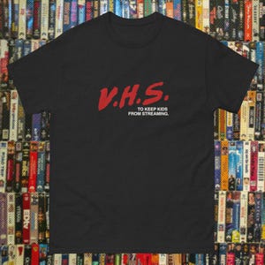 May include: Black t-shirt with a red graphic that says "V.H.S. To keep kids from streaming."