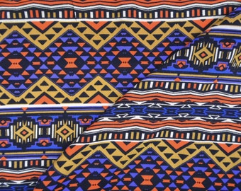 May include: A fabric with a repeating pattern of geometric shapes in shades of orange, red, blue, white, and brown. The pattern is reminiscent of Native American designs.