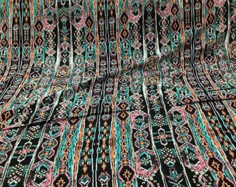 May include: Black fabric with a colorful geometric pattern. The pattern features vertical stripes with a mix of teal, pink, orange, and white accents.