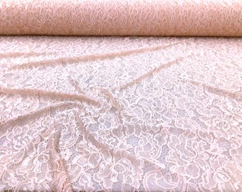 Tela de encaje elástico transparente con bordado floral metálico color rosa champán, cortada a medida.