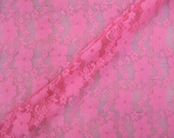 May include: Pink floral lace fabric with a delicate pattern. The lace is soft and sheer, and it has a slightly textured surface.