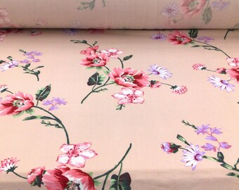 May include: Peach-colored fabric with a floral print featuring pink, white, and purple flowers. The fabric has a soft, smooth texture.