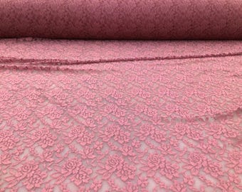 May include: Pink floral lace fabric with a delicate pattern. The lace is soft and sheer, making it perfect for a variety of projects.