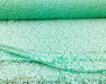 May include: Mint green lace fabric with a delicate floral pattern. The lace is soft and sheer, making it perfect for a variety of crafting projects.