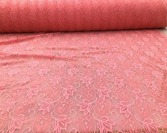 May include: A roll of pink lace fabric with a floral pattern. The lace is delicate and has a soft, feminine feel.