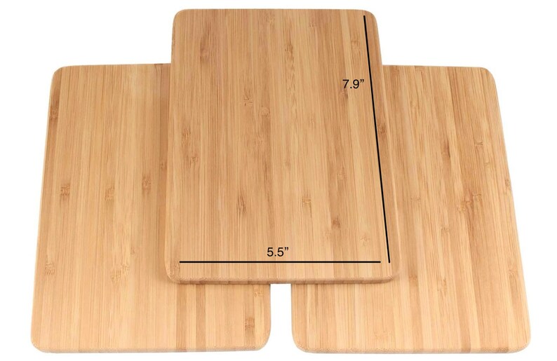 Op de afbeelding: Drie houten snijplanken van bamboe, op elkaar gestapeld. De bovenste plank is 7,9 inch lang en 5,5 inch breed.
