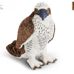 May include: A brown and white plush osprey bird toy with black eyes and a black beak. The toy is standing on a white surface. The toy is made by Living Nature.