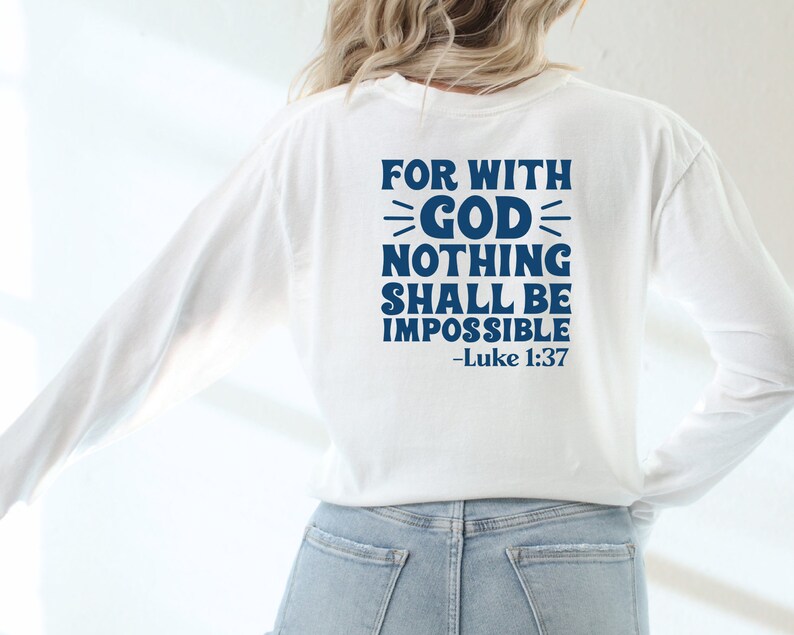 K&ouml;nnte beinhalten: Wei&szlig;es Langarmshirt mit blauem Text, der "For with God nothing shall be impossible - Luke 1:37" lautet.