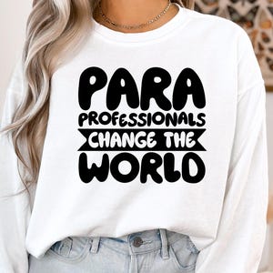 May include: White long-sleeved shirt with black text that reads "Para Professionals Change The World".