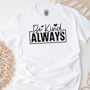 May include: White t-shirt with black text that reads "Be Kind ALWAYS" with two small hearts above the word "Kind".