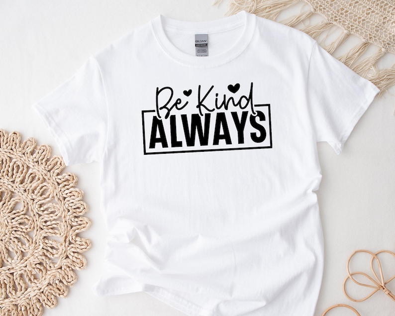 May include: White t-shirt with black text that reads "Be Kind ALWAYS" with two small hearts above the word "Kind".