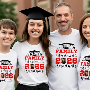 Peut inclure: Quatre personnes portant des t-shirts blancs avec l'inscription "PROUD FAMILY of a class of 2026 Graduate" en rouge et noir. Les chemises pr&eacute;sentent un motif de chapeau de graduation et une photo. Une personne porte une coiffe de graduation.