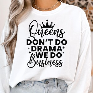 May include: White long-sleeve shirt with black text that reads "Queens Don't Do Drama We Do Business" and a crown graphic.
