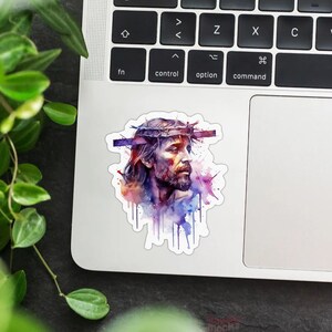 May include: A watercolor painting of Jesus Christ with a crown of thorns. The painting is in shades of purple, blue, and pink.