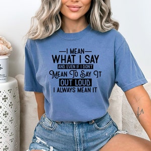 May include: A blue t-shirt with the text "I mean what I say and even if I don't mean to say it out loud I always mean it" printed in black.