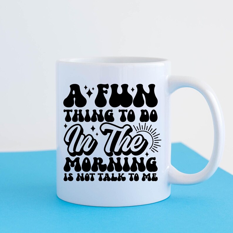 May include: White ceramic coffee mug with a black graphic that reads "A fun thing to do in the morning is not talk to me".