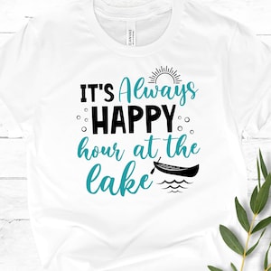 May include: White t-shirt with the text "It's Always Happy Hour at the Lake" in black and teal blue lettering. A sun and a canoe are also depicted on the shirt.