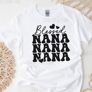 May include: White t-shirt with black text that reads "Blessed Nana Nana Nana" with a small heart graphic.