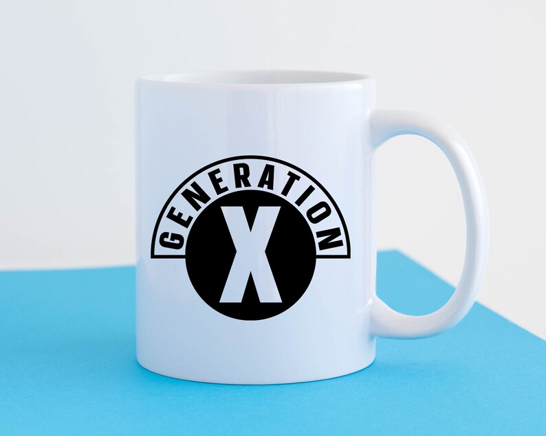 May include: White ceramic mug with a black graphic of a circle with the text "GENERATION X" and a black letter "X" inside the circle.