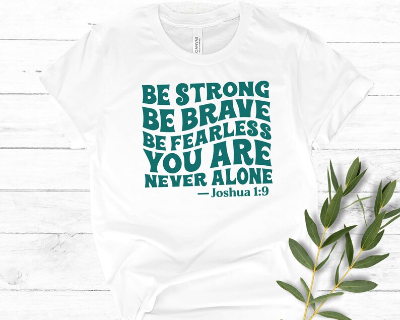 K&ouml;nnte beinhalten: Wei&szlig;es T-Shirt mit einer blaugr&uuml;nen Grafik, auf der steht: "Sei stark Sei mutig Sei furchtlos Du bist nie allein - Josua 1:9"