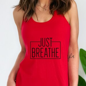 May include: Red tank top with a black graphic that says "JUST BREATHE" in a rectangle.