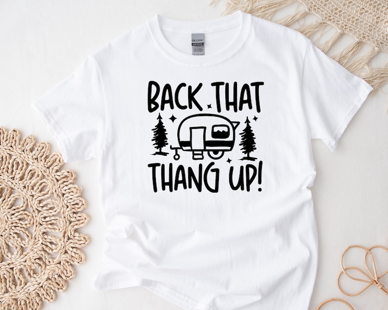 May include: White t-shirt with black text that reads "Back That Thang Up!" and a black silhouette of a camper with trees and stars.