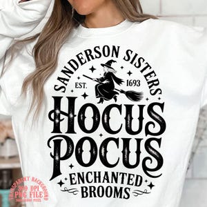 Könnte beinhalten: Weißes Sweatshirt mit einem schwarzen Grafikdesign mit dem Text "Sanderson Sisters Hocus Pocus Enchanted Brooms" und einer Hexe auf einem Besen. Das Design enthält das Jahr 1693 und Sterne.
