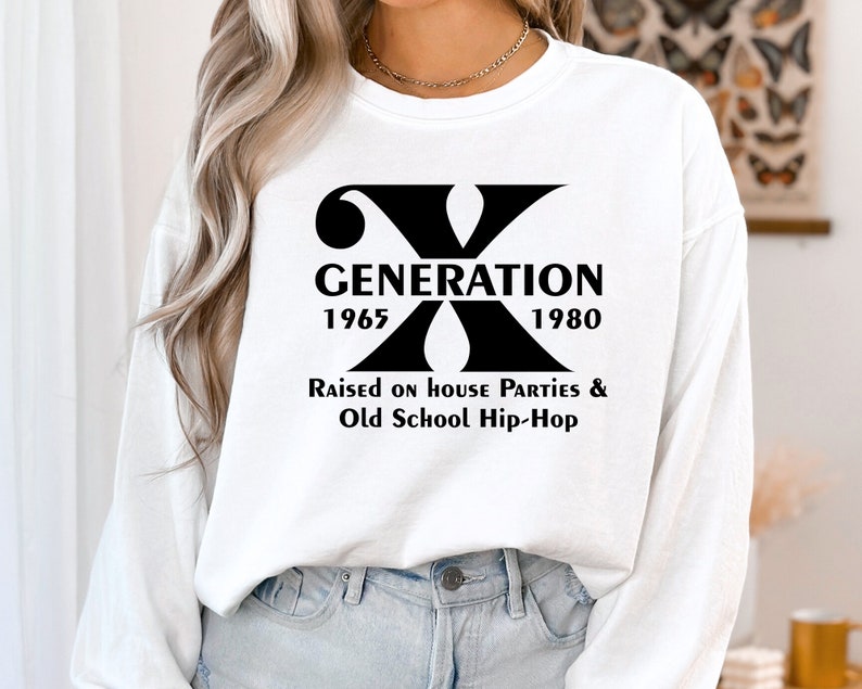 May include: White long-sleeve sweatshirt with a black graphic print of the letter X and the text "Generation 1965 1980 Raised on House Parties & Old School Hip-Hop".
